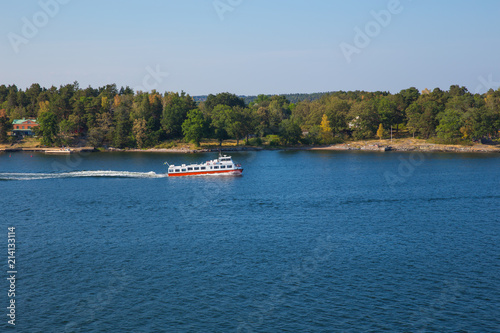 slands, water and houses. Ship and waves. Sunny day many trees on the island. photo