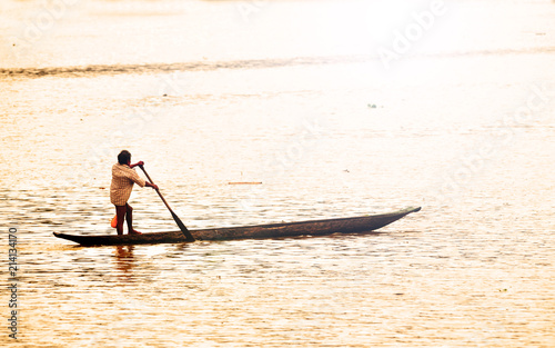 Embera Indian rowing his canoe across the Chagres river in Panama photo