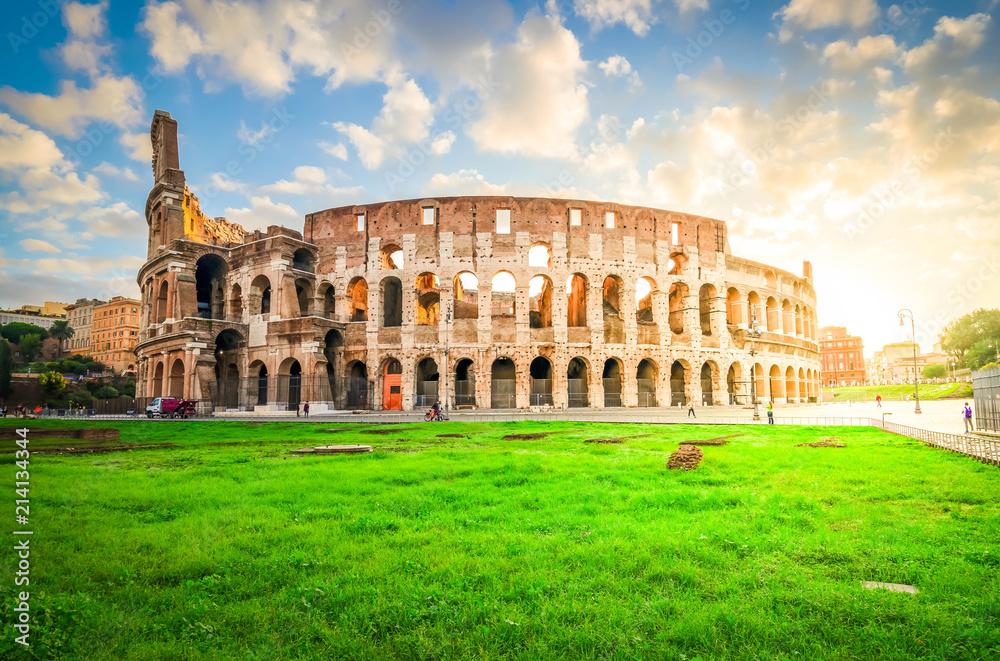 ruins of antique Colosseum with grass lawn in sunise lights, Rome Italy, toned