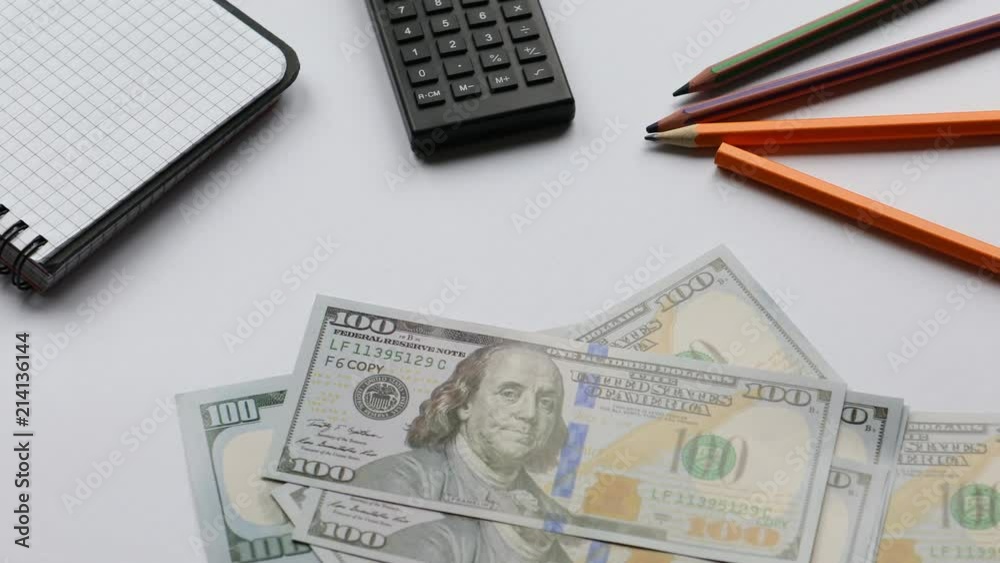 Counting money on the working desk with stationary, pack of dollars Counting money on the working desk with stationary, pack of dollars