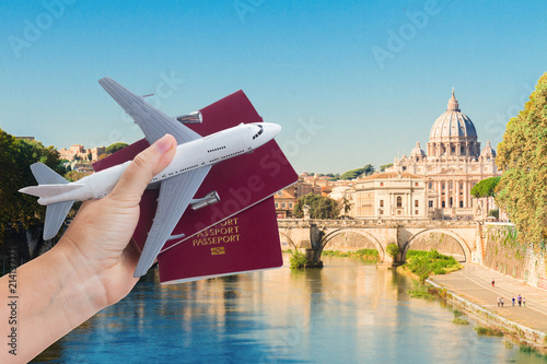 Photography Plane travel concept, hand holding passports with plane against Rome cityscape