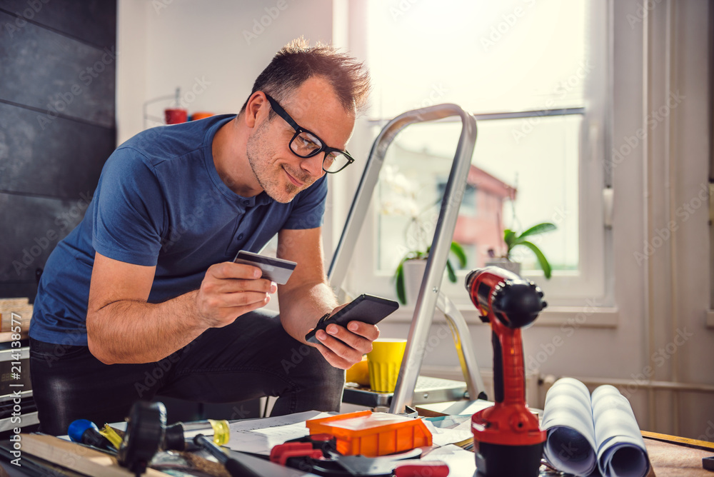 Men shopping online during kitchen renovation Men shopping online during kitchen renovation