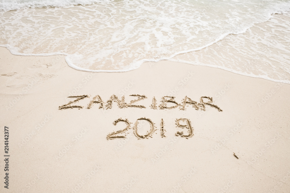 Zanzibar 2019 year description on light sand with waves