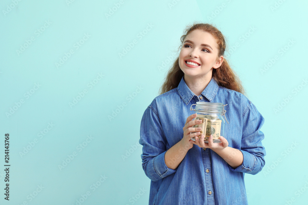Young woman holding glass jar with dollar banknotes on color background. Money savings concept Young woman holding glass jar with dollar banknotes on color background. Money savings concept