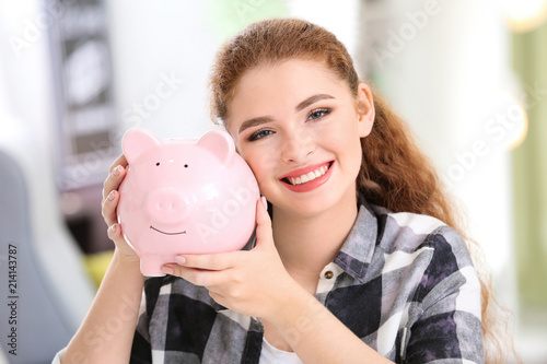 Young woman holding piggy b...