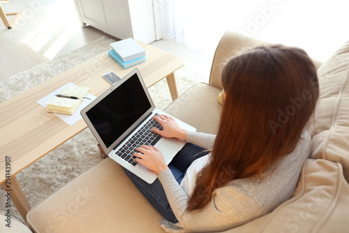Female freelancer working on laptop at home