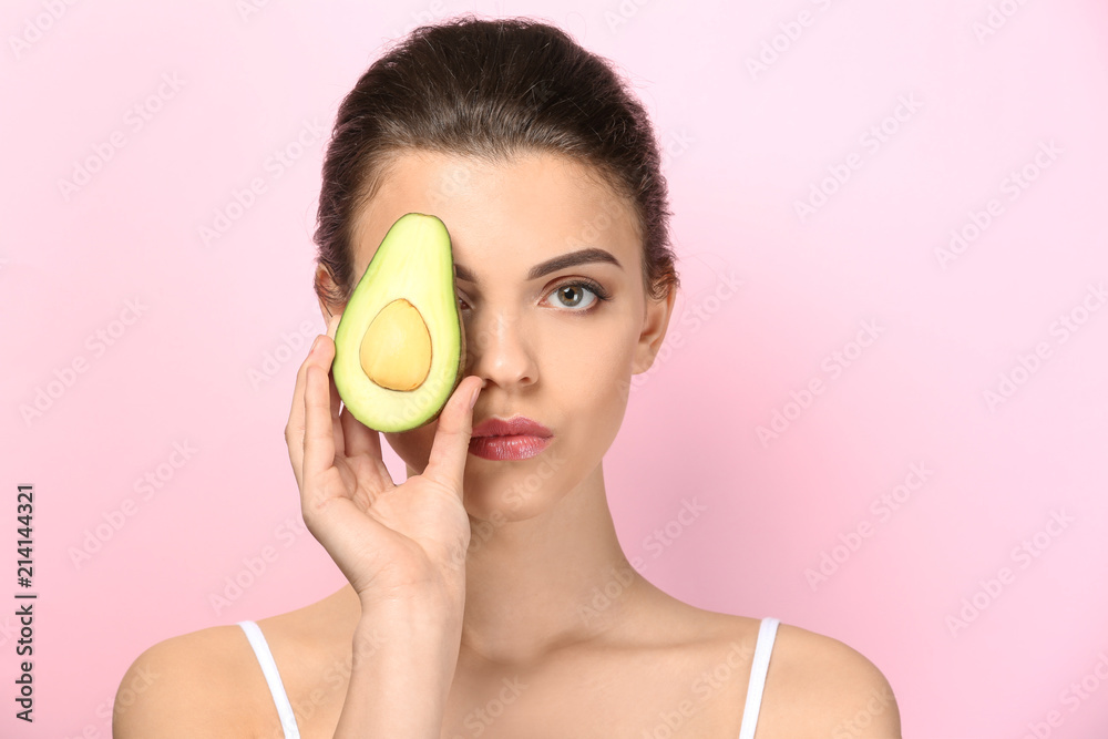 Beautiful young woman with avocado on color background Beautiful young woman with avocado on color background