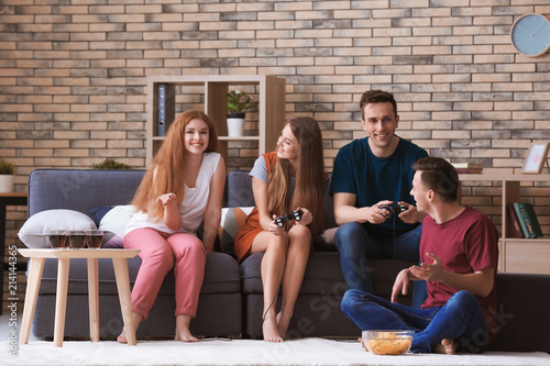 Young people playing video games at home