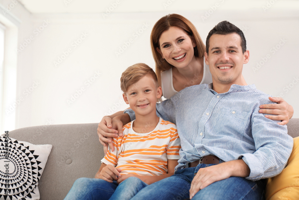 Happy family with cute child on sofa at home
