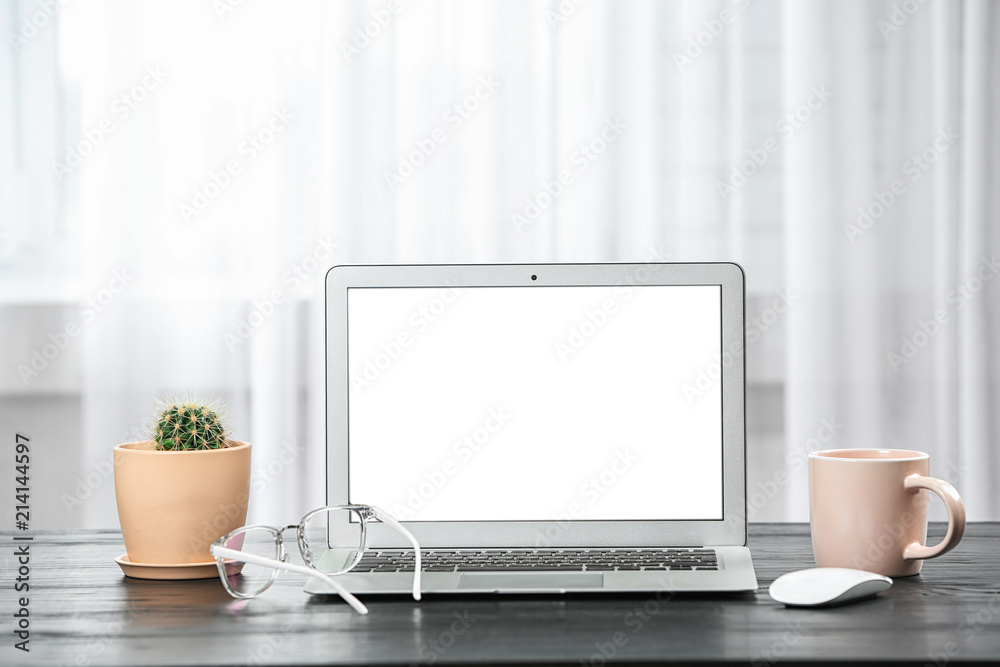 Fototapeta premium Laptop on desk near window in home office. Comfortable workplace
