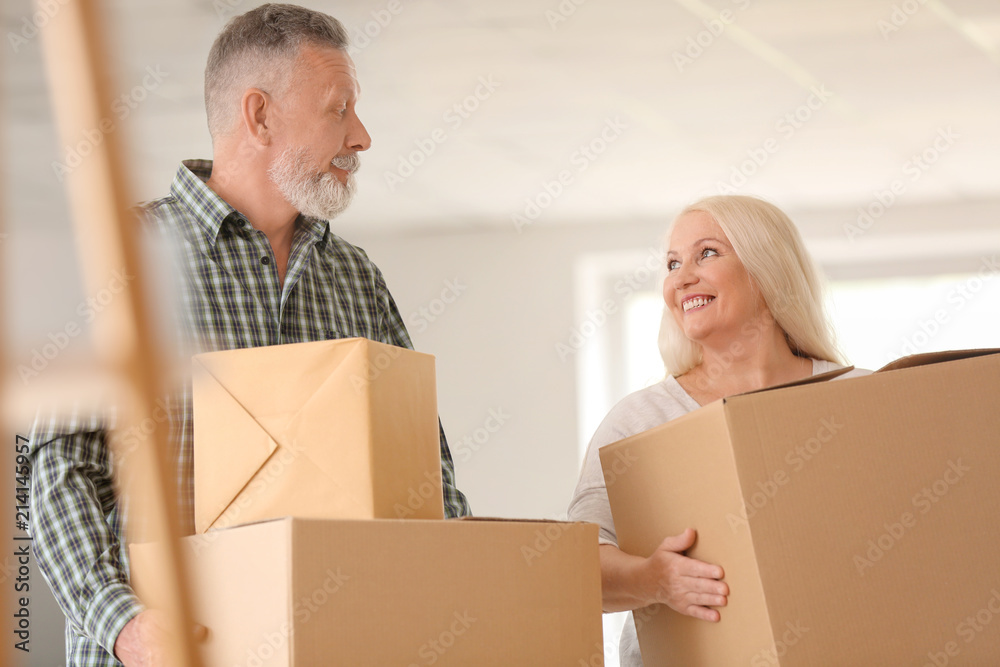 Mature couple with moving boxes at new home