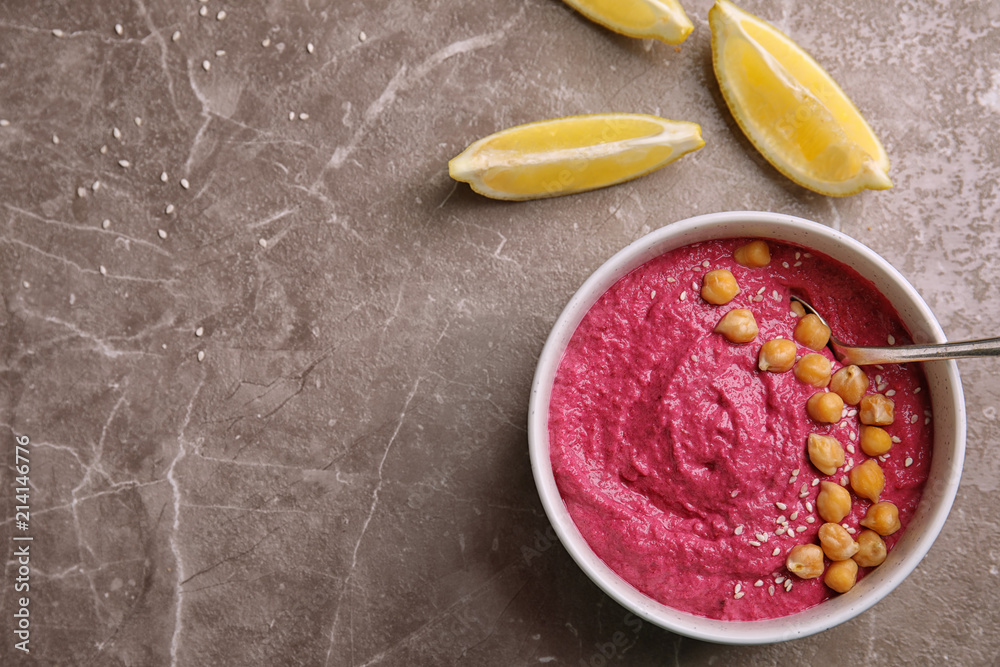Flat lay composition with bowl of fresh beet hummus and slices of lemon on gray background Flat lay composition with bowl of fresh beet hummus and slices of lemon on gray background