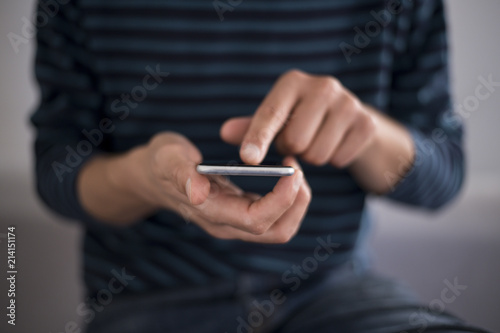 Young man using a touchscreen smartphone - Hands close-up - Using technology