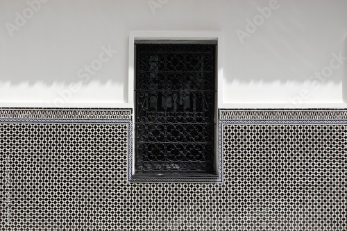 Fenêtre avec grille à motifs orientaux en fer forgé