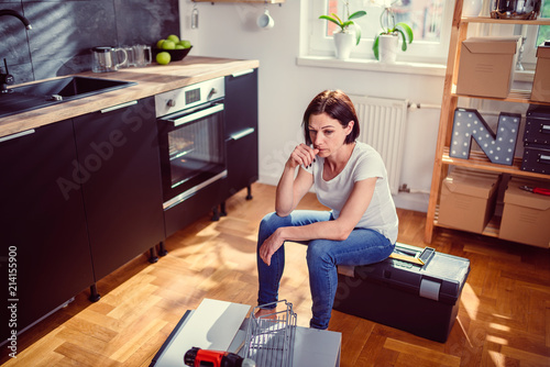 Tableau sur toile Worried woman renovating kitchen