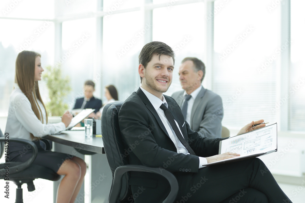 business man at office with his business team working behind business man at office with his business team working behind