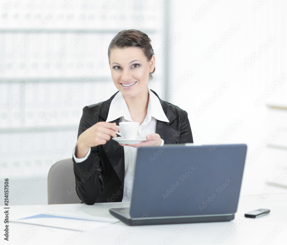 Executive business woman with coffee Cup sitting at her Desk