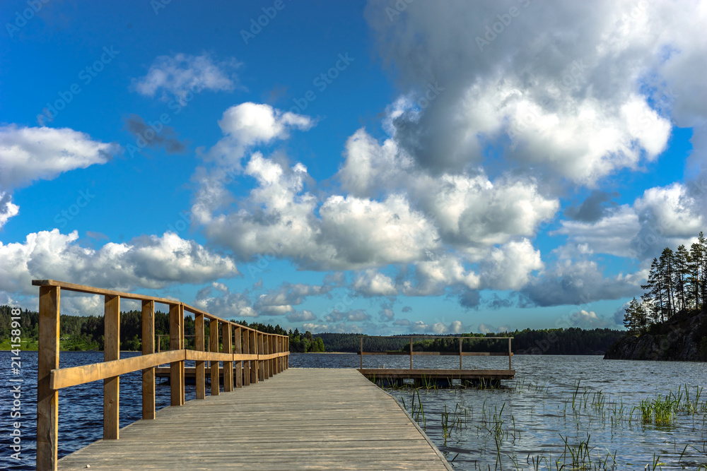 Berth. Blue sky in the summer. Pier in sunny weather. Clouds fly over the pier