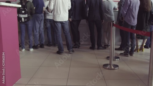 Queue of people waiting in line to be served. The queue of people standing in the cash. Could be a post office, bank or ticket sales agent