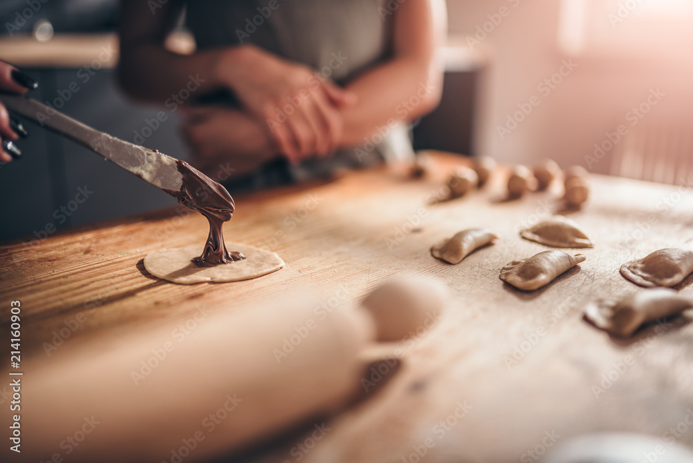 Woman filling ravioli with chocolate cream Woman filling ravioli with chocolate cream