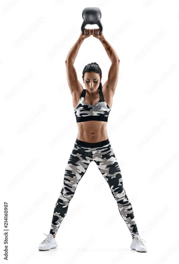 Fitness model working out with kettlebell. Photo of latin woman with good physique in fashionable sportswear isolated on white background. Strength and motivation. Full length Fitness model working out with kettlebell. Photo of latin woman with good physique in fashionable sportswear isolated on white background. Strength and motivation. Full length