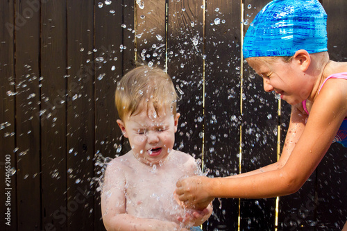 Girl Breaking a Water Balloon on Little Brother