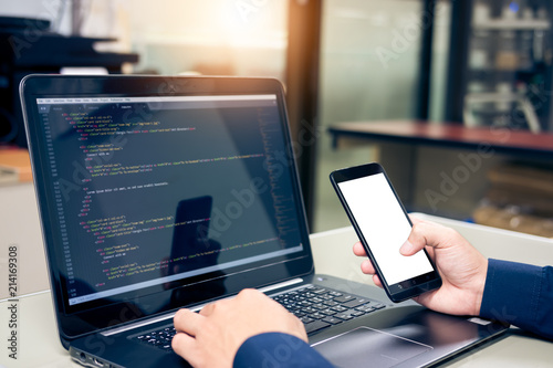 Developing programming and coding technologies on desk, Website design, Programmer working in a software develop company office,Preview code in Smartphone