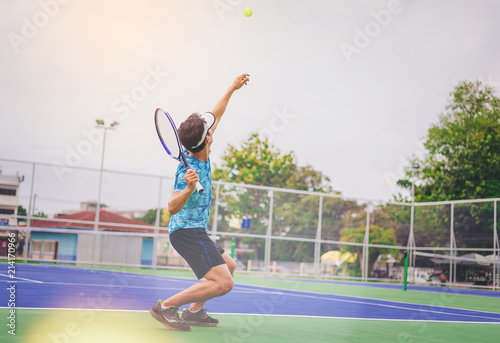 Tennis player serving in a tennis game. © Panumas