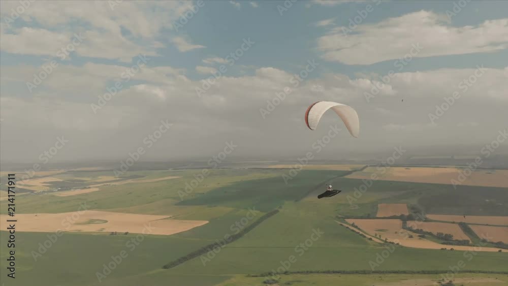 Athlete paraglider flies on his paraglider next to the swallows. Follow-up shooting from the drone Athlete paraglider flies on his paraglider next to the swallows. Follow-up shooting from the drone