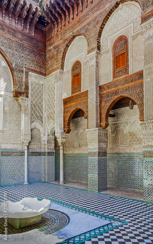 Ornate mosaic and carvings in a courtyard of a Moroccan medersa photo