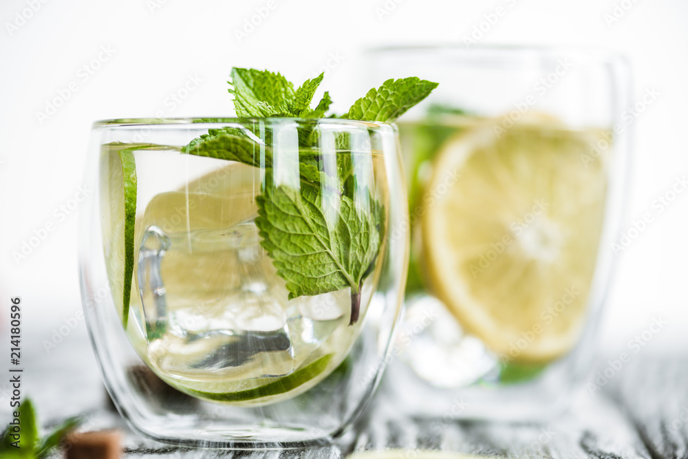 selective focus of fresh cold mojito cocktail in glasses on wooden table selective focus of fresh cold mojito cocktail in glasses on wooden table