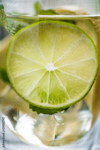 close-up view of glass with cold fresh mojito and slice of lime