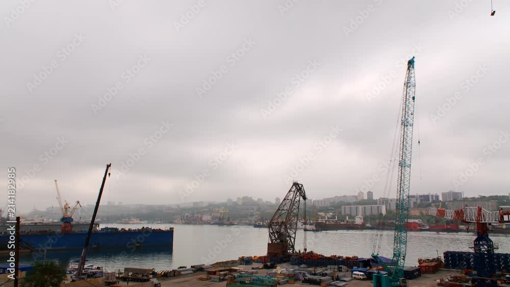 Industrial seaport of the Russky Island, Russia. View of city, ships, docks, cranes, cargo containers and other infrastructure of the seaport Industrial seaport of the Russky Island, Russia. View of city, ships, docks, cranes, cargo containers and other infrastructure of the seaport