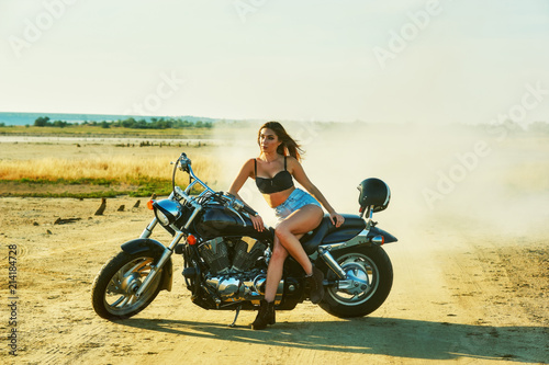 Young woman resting sitting on a motorcycle . Travel and tourism concept