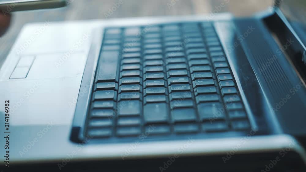 Man Fingers Taping Keyboard Notebook Computer. Uses smartphone. Close up. Man Fingers Taping Keyboard Notebook Computer. Uses smartphone. Close up.