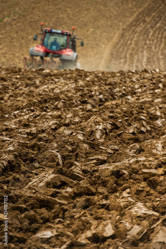 Farmer on tractor plow field, France photo