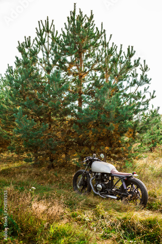 Silver old motorbike parking on a country road. Everything is ready for having fun after hard day in office. Modern young businessman hipster hobby. Space for your individual text.