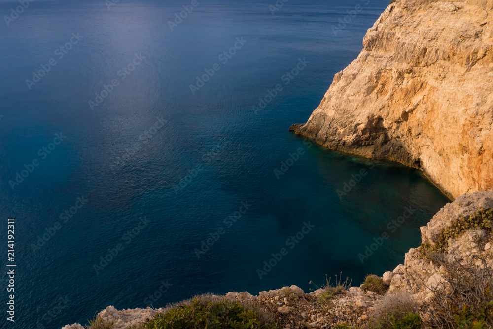 Top view of blue ocean with rocks at sunset