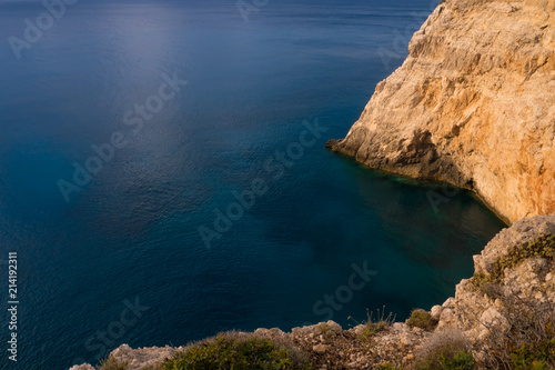 Top view of blue ocean with rocks at sunset