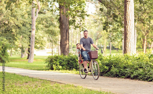 Family cycling outdoors - family on bicycles in park.