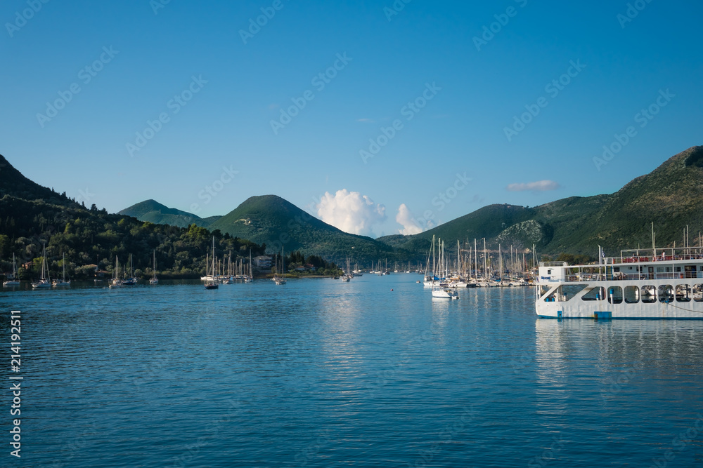 Landscape of a little harbour with blue ocean and sky and white boats