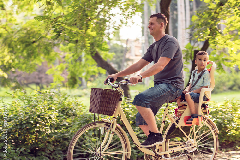 Happy family. Father and son riding bike in the park. Family sport and healthy lifestyle.