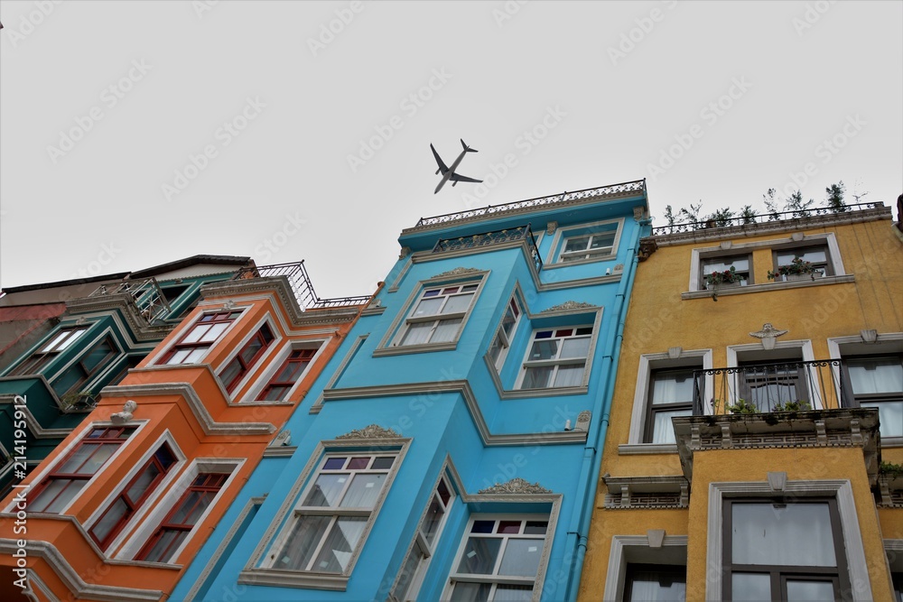Obraz premium A plane is flying low over Balat houses
