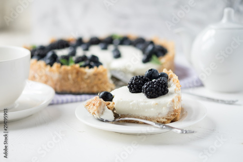 Piece of cheesecake with blueberries and blackberries with white service