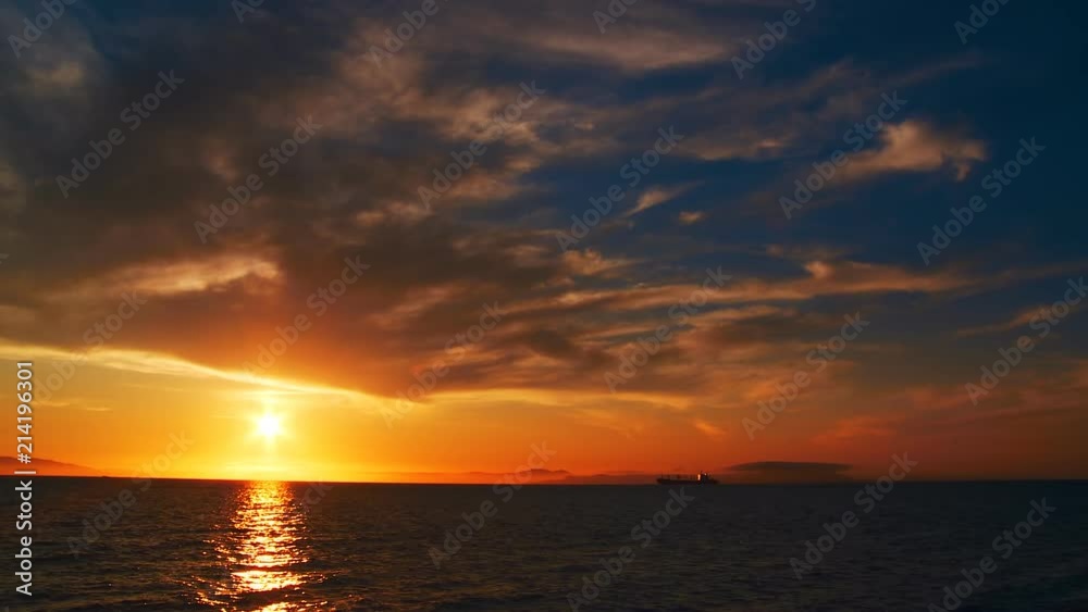 A beautiful sunset in the clouds, on the surface of the ocean, the waves shine brightly in the sun, far away is the mountains in light evening haze. Color correction options A beautiful sunset in the clouds, on the surface of the ocean, the waves shine brightly in the sun, far away is the mountains in light evening haze. Color correction options