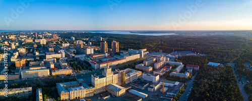 Aerial drone panoramic view of university campus in the city center of Chelyabinsk, huge city park with coniferous forest, recreation zone in polluted city, sunny evening in South Ural capital, Russia photo