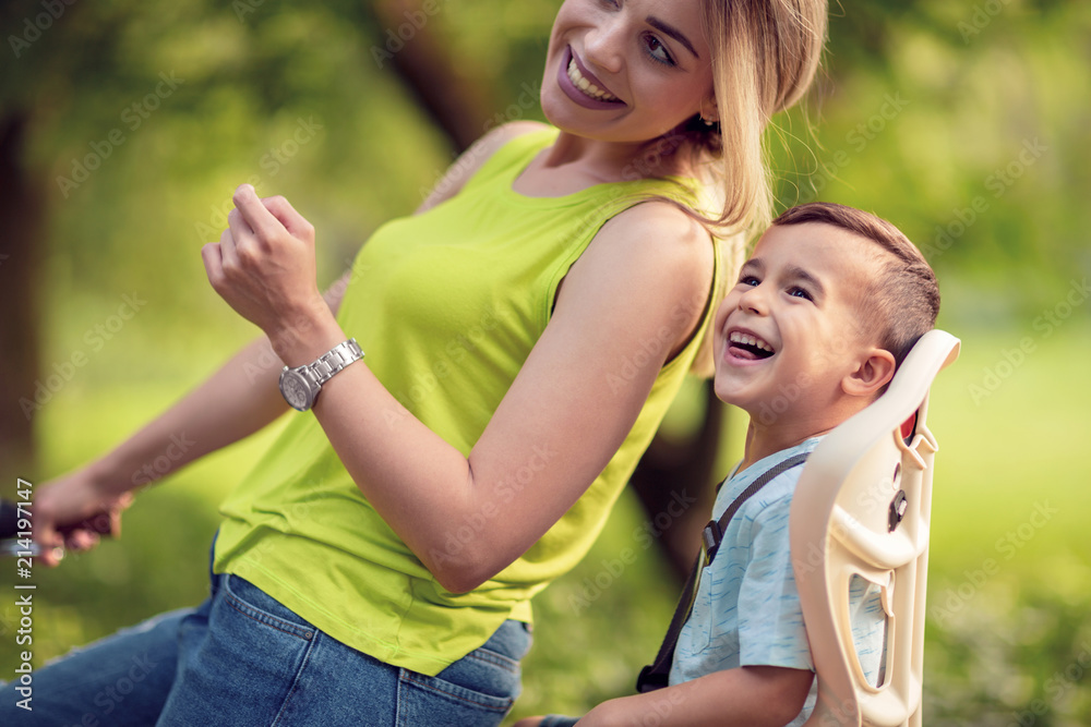 Fototapeta premium Young mother and boy biking at summer warm day.
