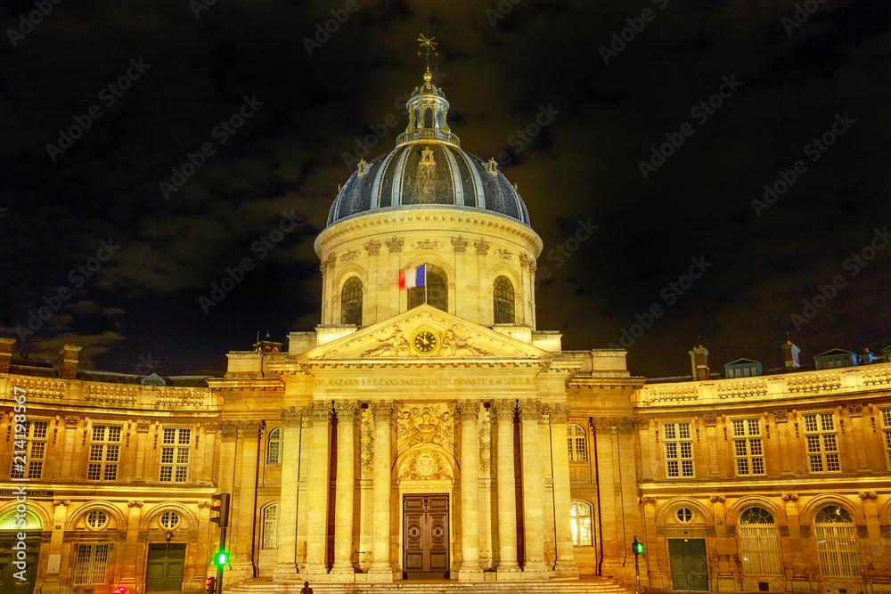 Central dome of Institut de France building, a French learned society group of five academies in Paris, France, Europe. Institut de France with Bibliotheque Nazarine illuminated by night.