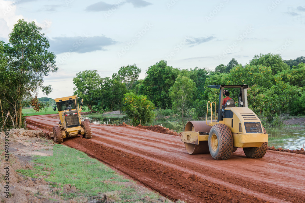 Obraz premium Roller steamroller or vibratory roller machine and motor graderworking on road construction site of new road.