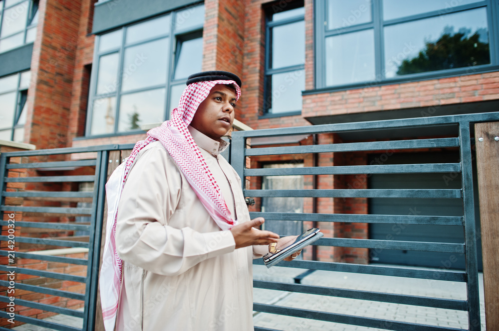 Fototapeta premium Middle Eastern arab man posed on street against modern building with tablet at hands.